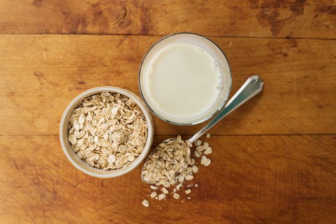 Oats and oat milk against wood