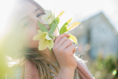Portrait of girl smelling yellow flowers