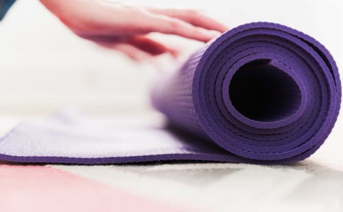 Woman's hand rolling yoga mat