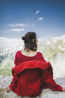 Switzerland, Appenzell, Woman in red jacket looking at mountain landscape