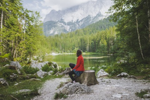 Germany, Bavaria, Eibsee, Woman sitting by Frillensee lake