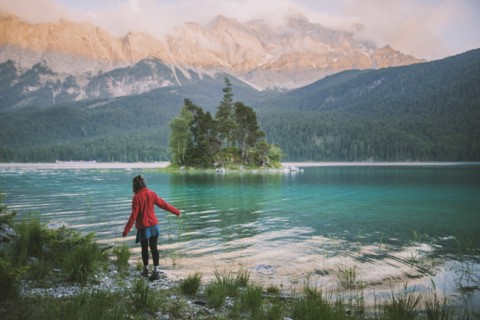 Germany, Bavaria, Eibsee, Young woman walking at shore of Eibsee lake in Bavarian Alps