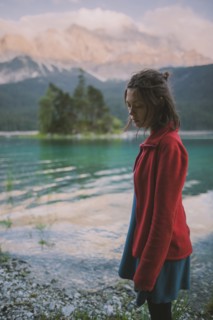 Germany, Bavaria, Eibsee, Young woman standing at shore of Eibsee lake in Bavarian Alps