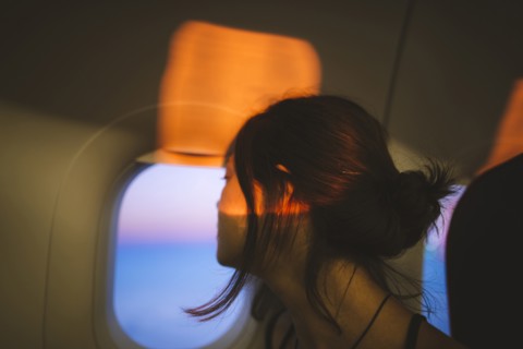 Portrait of young woman in plane illuminated with sunset light