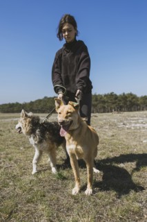 Young woman walking with dogs from animal shelter
