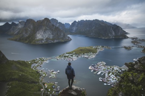 Norway, Lofoten Islands, Reine, Man looking at fjord from Reinebringen mountain