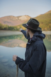 Italy, Man pointing towards mountains