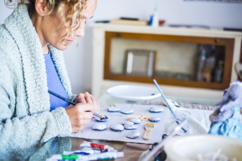 Woman painting stones at home