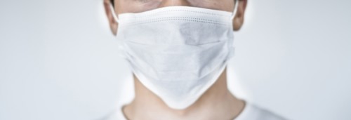 Studio shot of teenage boy (16-17) wearing protective mask