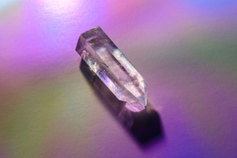 Quartz crystal on purple background