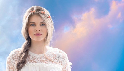 Woman wearing flower crown against overcast sky