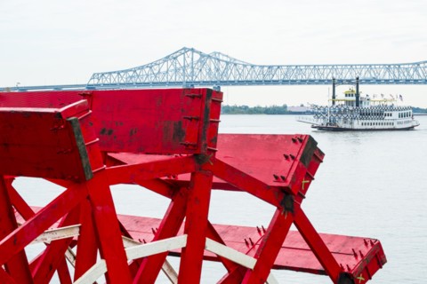 Mill wheel with Crescent City Connection bridge in distance in New Orleans, USA
