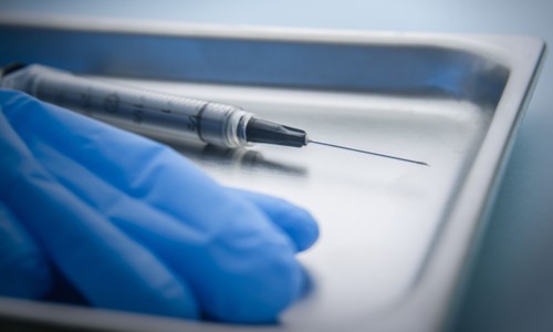 Needle and latex gloves on tray