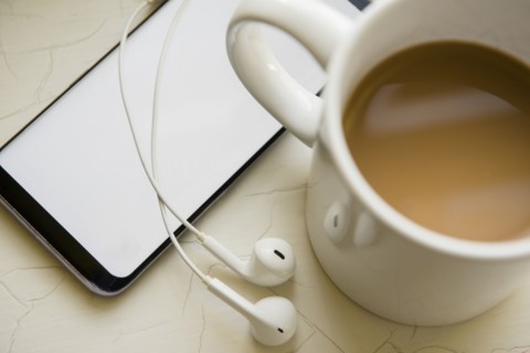 Earphones, smart phone and cup of coffee