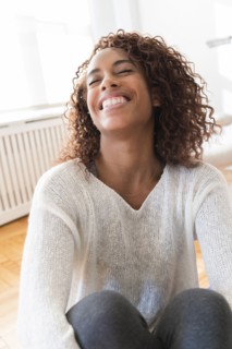 Smiling woman hugging her knees