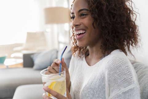 Smiling woman holding drink with straw