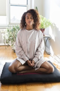 Woman meditating on cushion