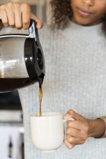 Woman pouring cup of coffee