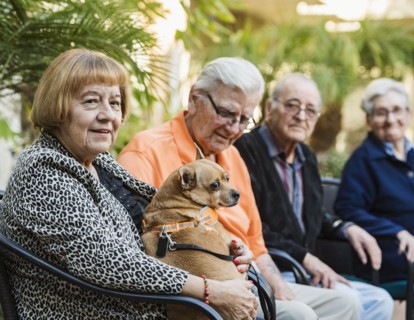 Senior people sitting in chairs with dog