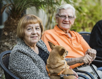 Smiling senior man and woman with dog