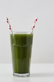 Green juice in cup with straws