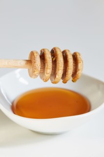 Honey dipper on bowl of honey