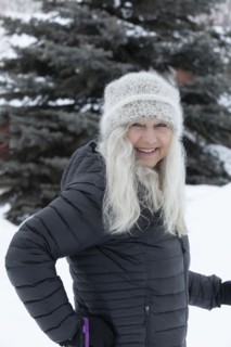 Smiling woman wearing hat and jacket in snow