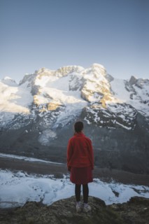 Woman standing on rock by Gorner Glacier in Valais, Switzerland