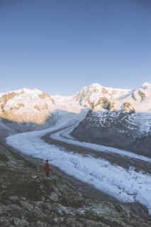 Woman standing on rock by Gorner Glacier in Valais, Switzerland