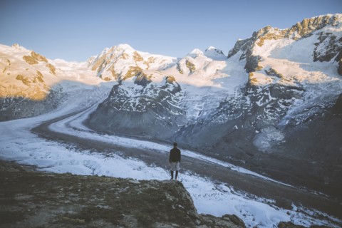 Man standing on rock by Gorner Glacier in Valais, Switzerland