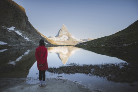 Woman standing by Matterhorn mountain and lake in Valais, Switzerland