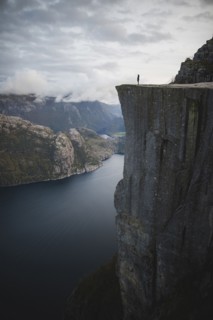 Person standing on Preikestolen cliff in Rogaland, Norway
