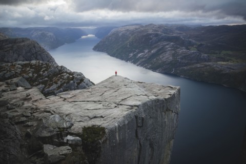 Person standing on Preikestolen cliff in Rogaland, Norway