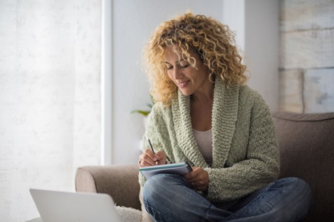 Smiling woman working with laptop on sofa