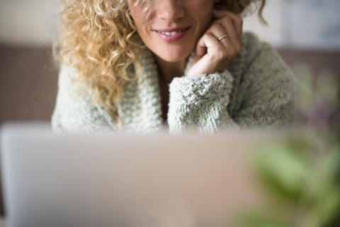 Woman smiling behind laptop