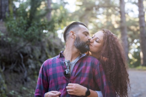 Couple kissing by trees