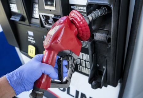 Gloved hand holding gas station nozzle
