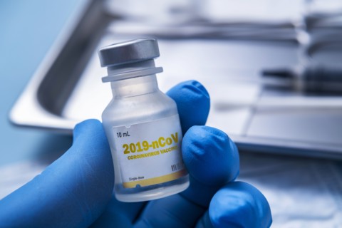 Close-up of gloved hand holding vial of Coronavirus vaccine