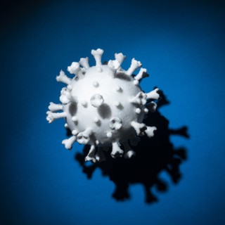 Model of white Coronavirus against blue background