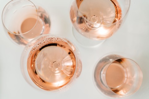 Glasses of rose wine on white background