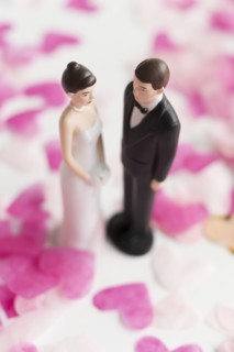 Bride and Groom cake toppers among heart shape confetti