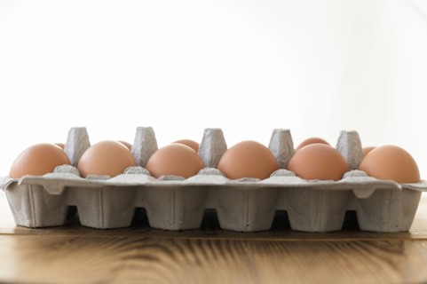 Carton of eggs on wooden table