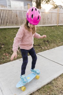 Girl skateboarding down a sidewalk