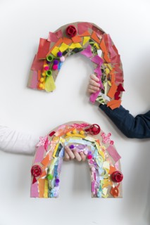 Kids hands holding their rainbow arts and crafts