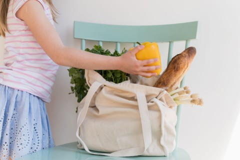 Girl unpacking products from reusable bag