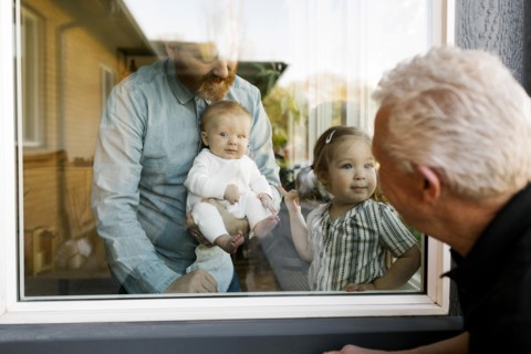 Grandfather visiting family with grandchildren (2-3 months, 2-3) through window