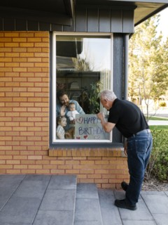 Grandfather visiting family with grandchildren (2-3 months, 2-3) through window