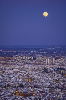 Spain, Andalusia, Seville, Moonrise over cityscape
