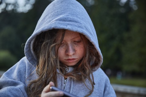 Girl in hoodie using phone