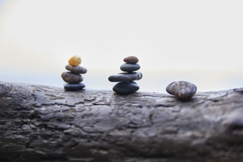 USA, Washington, San Juan County, Orcas Island, Stacks of pebbles on log